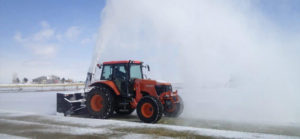 Equipment removing snow from sports turf